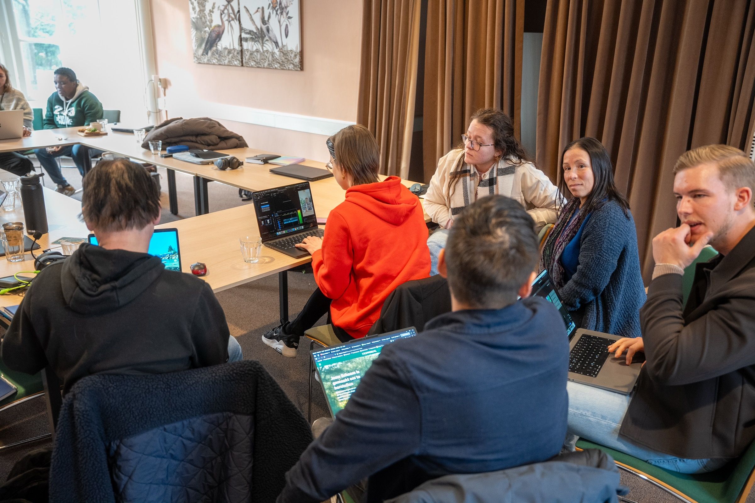 Studenten overleggen met laptops tijdens een edit-middag